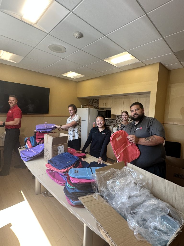 Steet Ponte Auto Group employees packing backpacks with supplies for the 2nd Annual Steet Ponte Auto Group School Supplies Drive