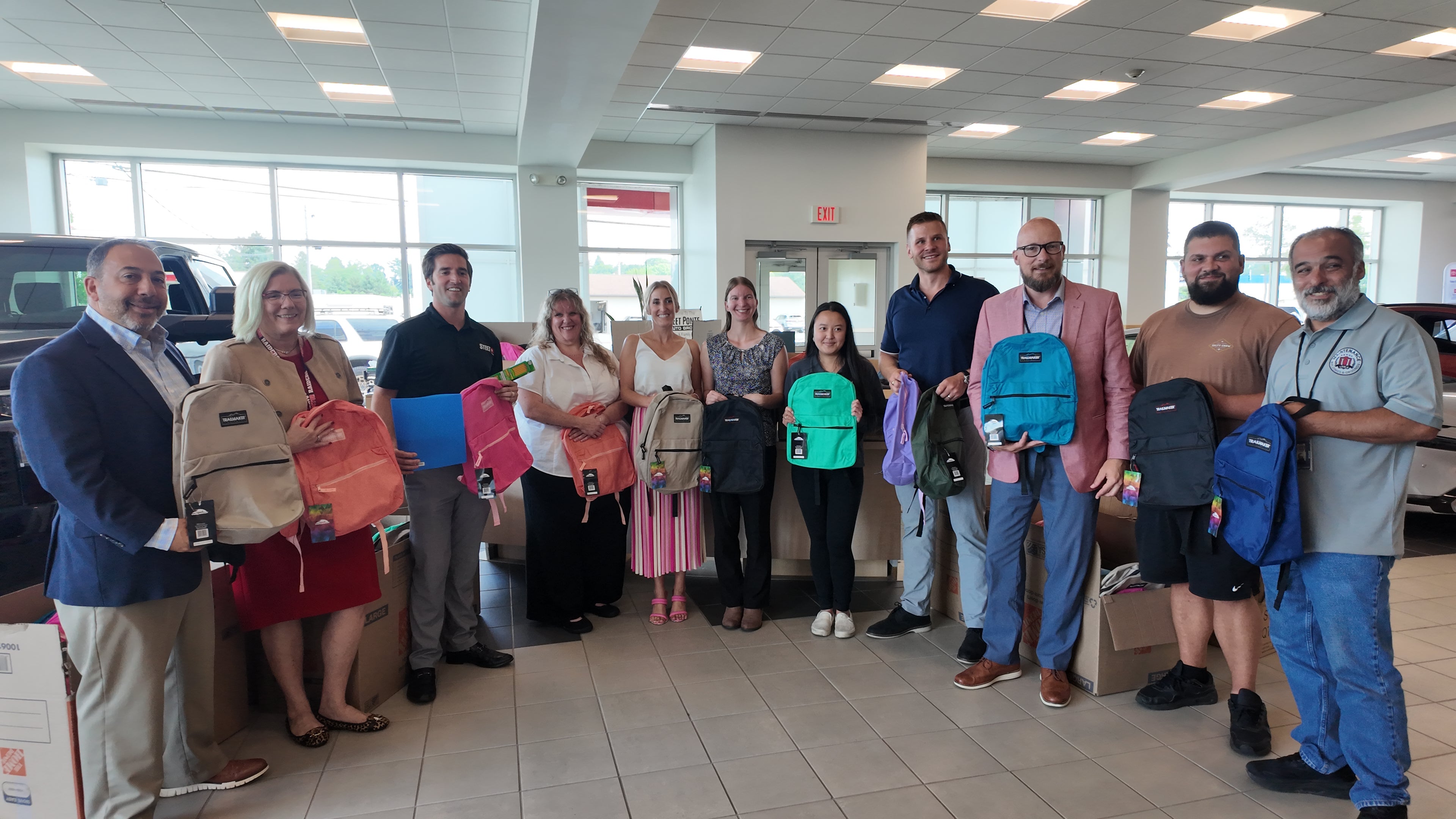 Steet Ponte Auto Group Representatives Presenting Backpacks to Utica City School District Representatives